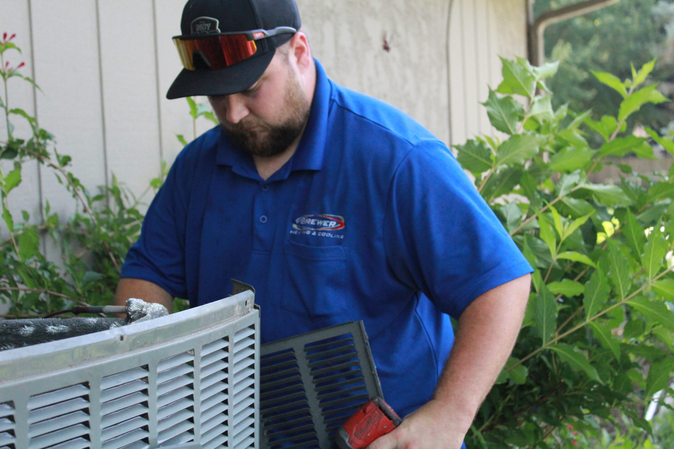 Brewer technician cleaning and repairing air conditioning unit in Franklin Township home