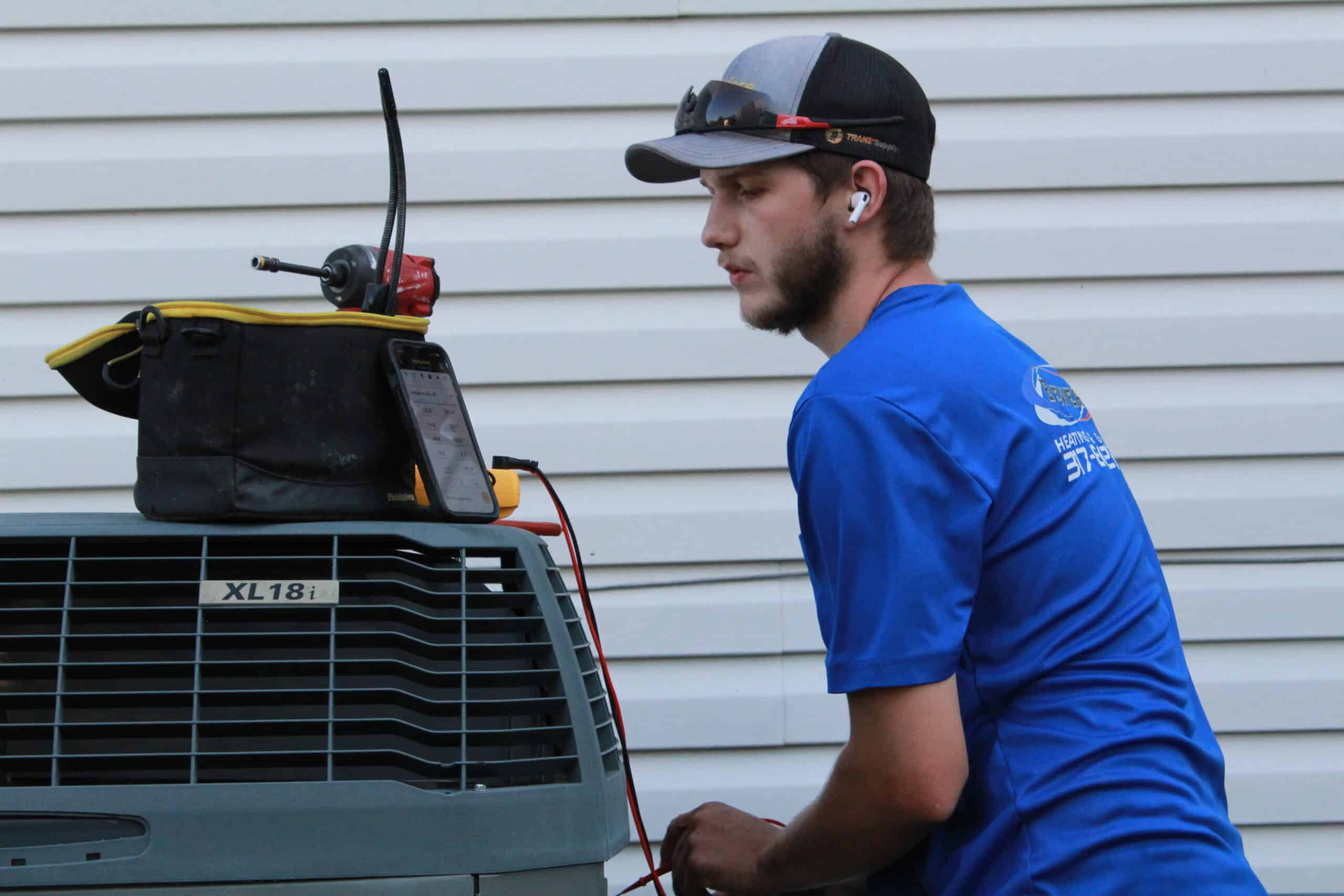Emergency air conditioning repair technician diagnosing issue
