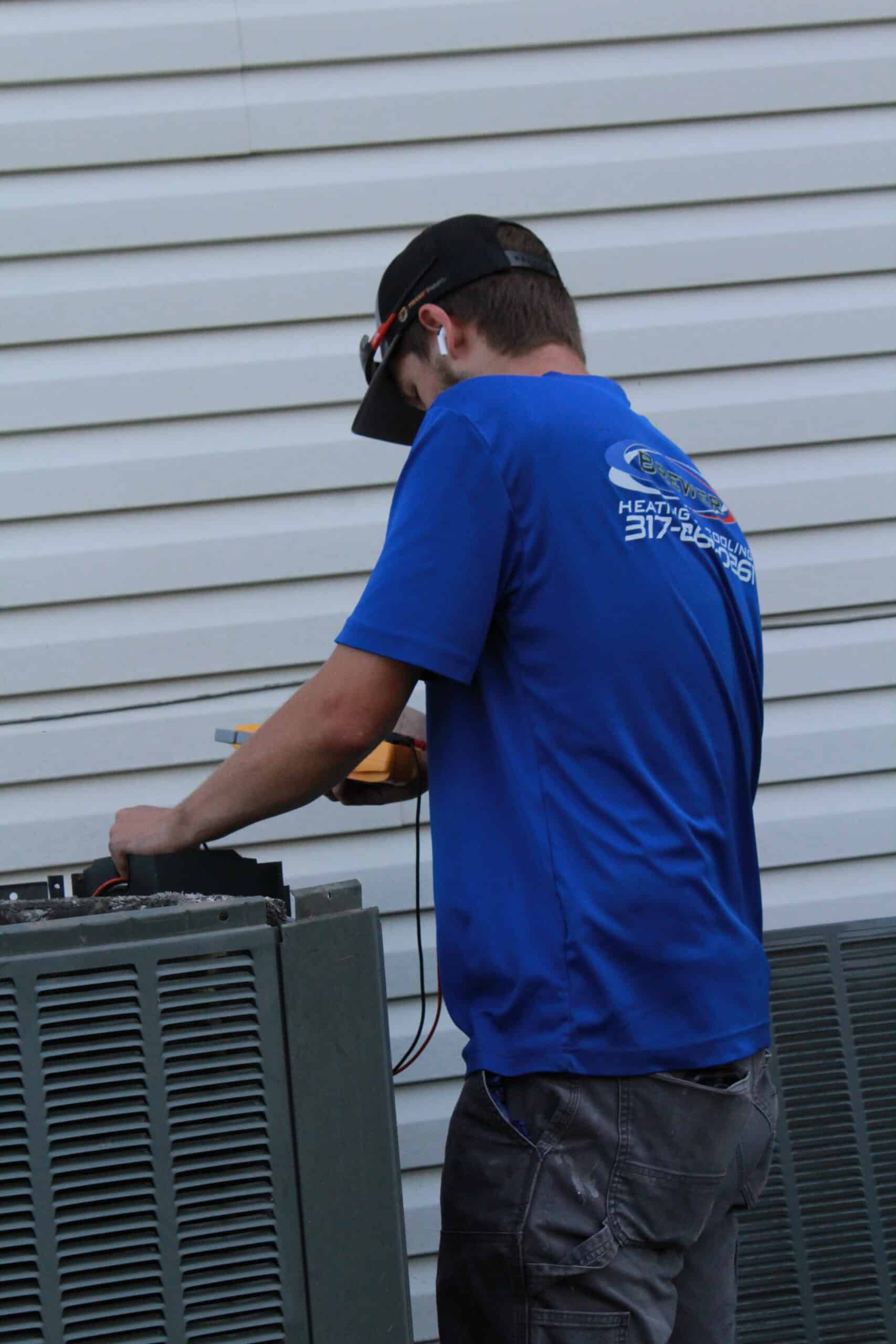 Brewer technician installing air conditioning unit in Southport Indianapolis area