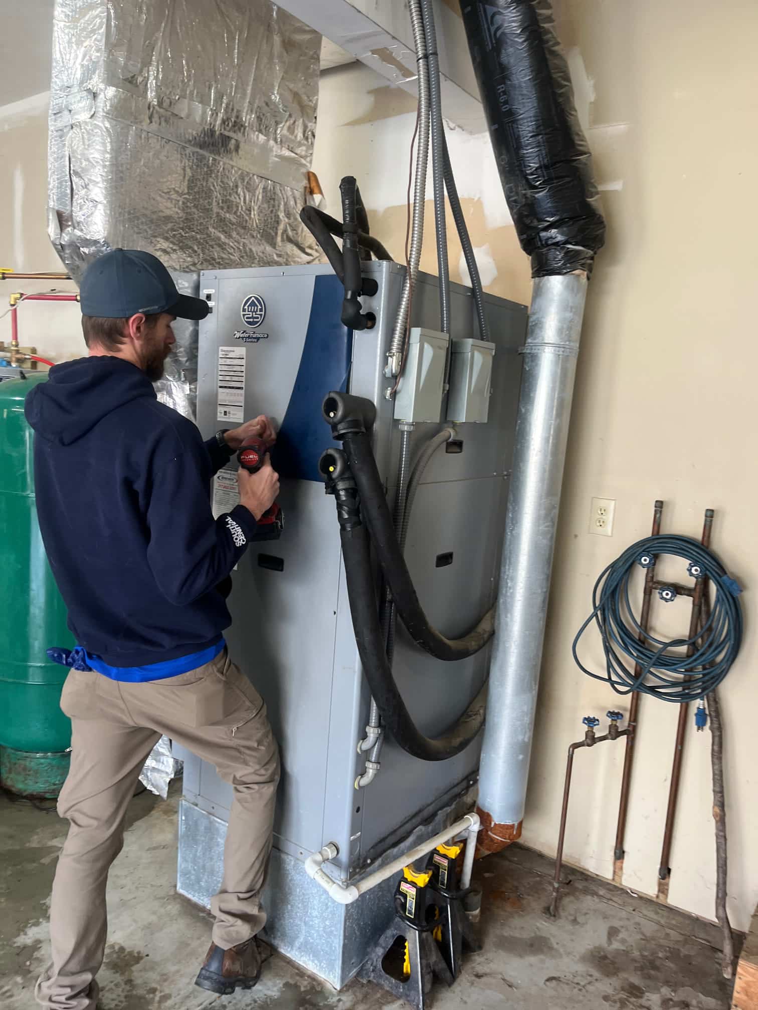 Brewer technician conductin maintenance on geothermal unit in Beech Grove home
